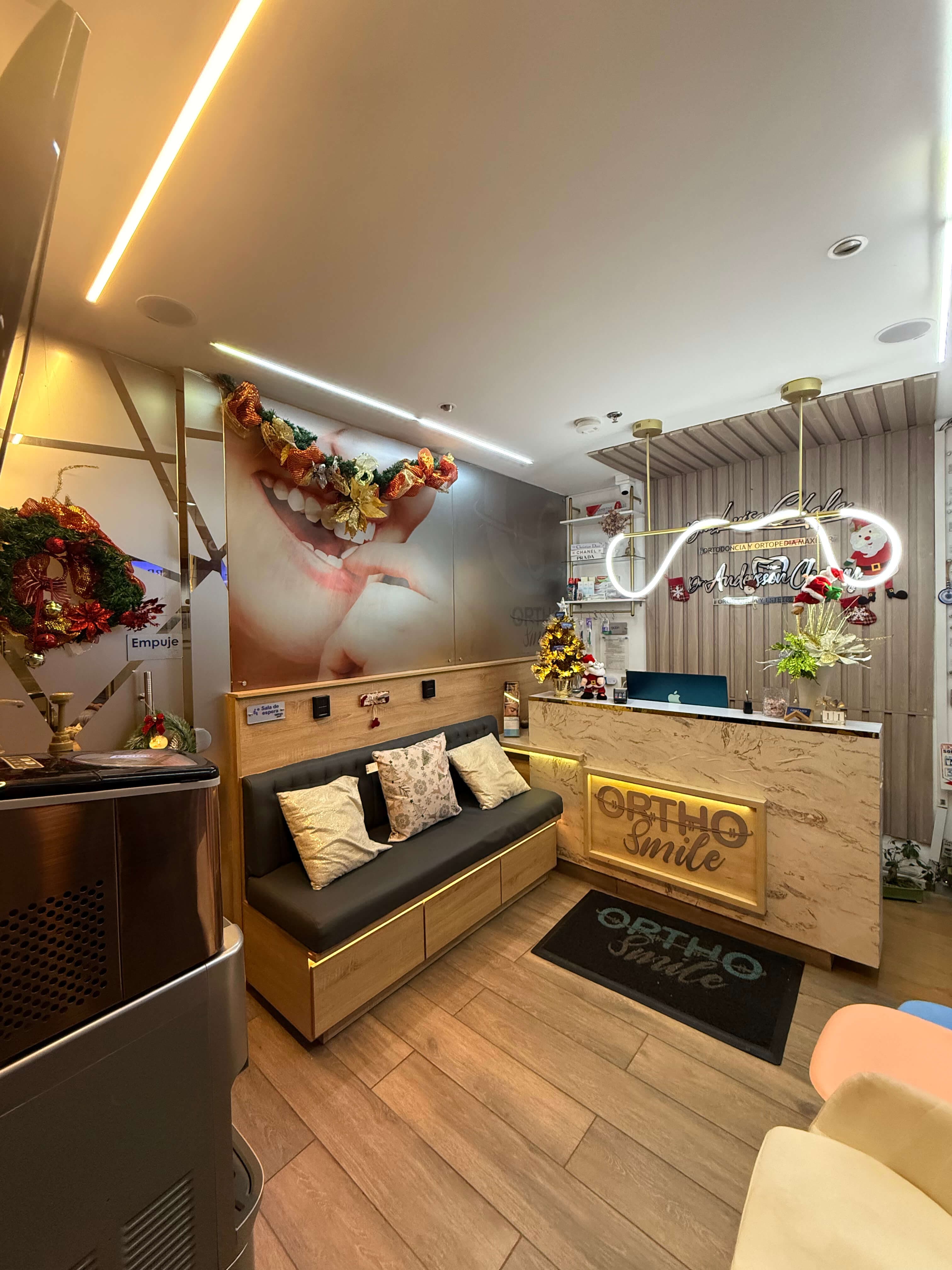 Recepción de OrthoSmile con sofá de espera y counter iluminado